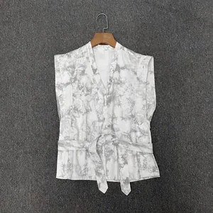 Détail du haut sans manches à col en V avec taille nouée et imprimé marbre gris texturé