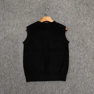 Close-up of black knit vest featuring ribbed edges and vertical back seam detail