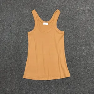 Detailed flat lay of ginger yellow cotton tank top with U-neck and soft knit texture