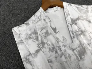 Détails du col en V et motif marbré gris sur le gilet blanc en texture de lin