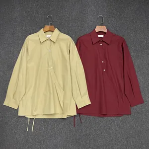 Detail of cotton shirts with wrap front, turndown collar and adjustable drawstring hem