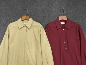Detail of khaki and dark red cotton shirts featuring wrap waist and lapel collar
