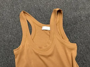 Close-up of ginger yellow ribbed cotton tank top showing texture and neckline detail