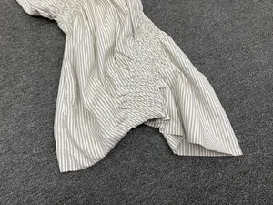 Detailed view of elastic smocking craft and black-white pinstripe fabric texture