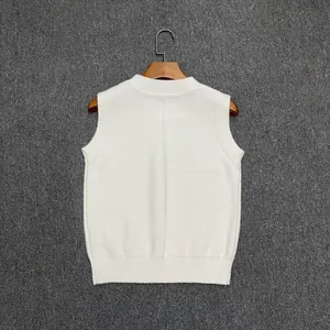 Detailed close-up of white wool knit vest showing ribbed neckline and vertical back seam