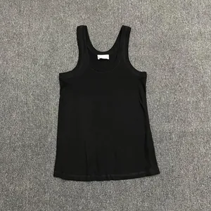 Detailed flat lay of black cotton U-neck tank top with wide straps on grey carpet