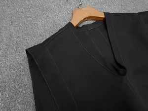 Détail du gilet sans manches à col en V avec surpiqûres contrastées et texture canvas