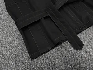 Détail du tissu noir à fines rayures avec ceinture assortie et tissage sergé précis
