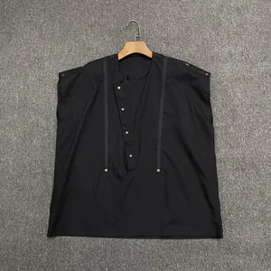 Detail of black relaxed blouse featuring asymmetric collar and silver metal buckles