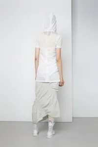Detail of white hooded mesh top with light striped gathered fishtail midi skirt