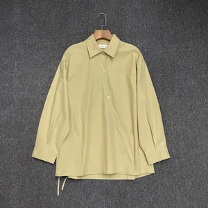 Detail of ginger cotton long sleeve shirt with asymmetrical wrap and tie-side hem
