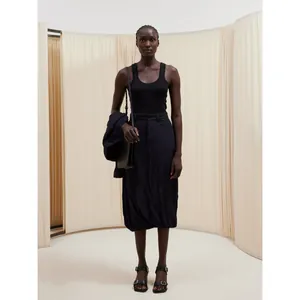Chic black cotton U-neck tank top paired with textured midi skirt and stylish accessories