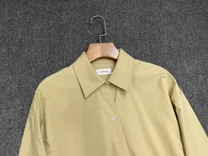 Detail of lapel collar and white buttons on a light khaki cotton wrap shirt