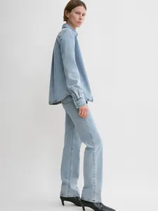 Minimalist light blue denim shirt and straight jeans set with black pointed boots