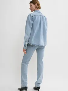 Detail of light blue denim shirt back featuring dropped shoulders and box pleat design