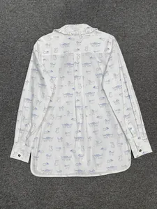 Détail du col à volants et imprimés chats bleus sur une chemise blanche en coton
