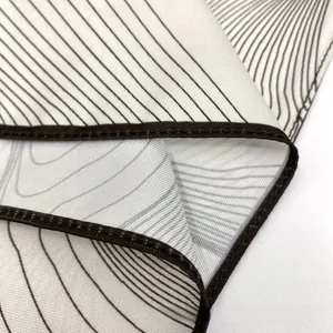 Close-up of geometric silk scarf with wavy print and high-quality rolled hem detail