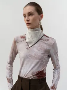 Detail of elegant V-neck marble print top with scarf collar and fine brown edges