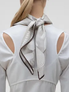 Detailed view of the silk scarf tied in a knot showing abstract wave pattern on back