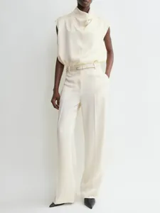 Detail of elegant cream satin trousers with a smooth drape and sophisticated texture