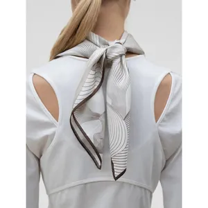 Elegant silk scarf with brown wave patterns and fine rolled edges tied on neck