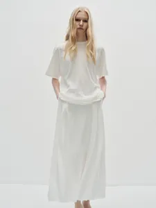 Detail of minimalist ivory white cotton T-shirt and maxi skirt set with soft texture