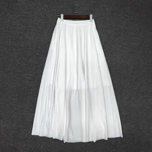 Detail showing white pleated A-line skirt with lightweight breathable fabric texture