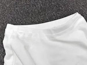 Detailed close-up of the white A-line skirt waist showing fine double stitching texture