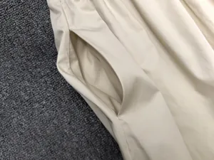 Detail of side pockets on a beige cotton A-line skirt with neat stitching craftsmanship