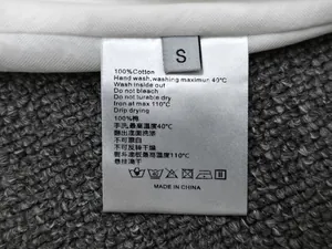 Close-up of 100% cotton fabric care label and size S tag on elastic waist skirt