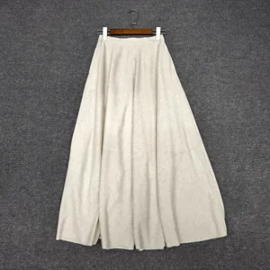 Detail of loose A-line long skirt in beige with an elastic waist and knit texture