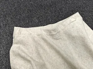 Detail shot of light grey A-line skirt waist showing premium stitching and fabric texture