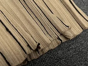 Macro shot of khaki ribbed knit fabric featuring delicate black vertical stripe texture