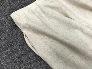 Close-up of oatmeal knit skirt with elastic waist stitching and side pocket detail