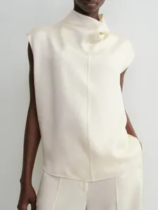 Close-up of cream sleeveless satin top featuring a high cowl neck and central seam detail