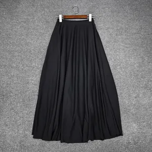 Detail of a high-quality long black A-line skirt with elegant pleats and drape