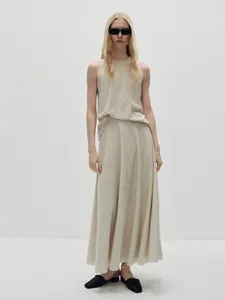 Detail of the minimalist beige cotton tank top showing its fluid lines and ribbed texture
