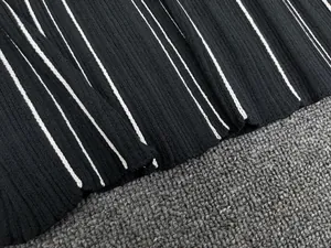Detail of black and white striped ribbed knit fabric showing texture and elasticity