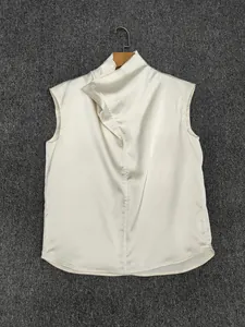 Detail of elegant ivory satin sleeveless top showing the smooth texture and drape