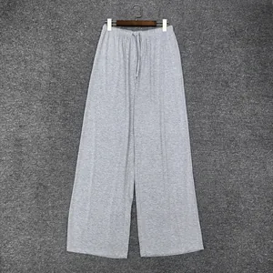 Détail du pantalon large gris montrant la taille élastique et le cordon de serrage