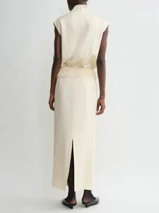 Detail view of cream satin skirt featuring elegant fringe trim and back hem slit