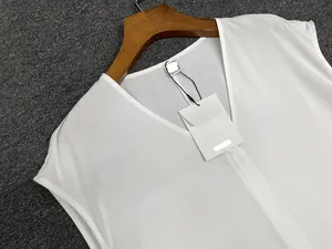 Detail view of white V-neck sleeveless linen top with texture on grey background