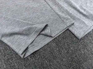 Détail du pantalon gris montrant les coutures doubles et la texture douce du tissu en tricot