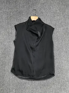Detail of elegant black sleeveless satin top with draped cowl neckline and silk texture