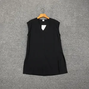 Detail view of the black sleeveless V-neck top showing side slits and a smooth fabric finish