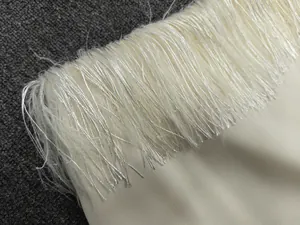 Macro detail of high-quality cream satin fabric with dense silky fringe trim