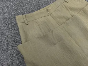 Macro shot of olive green high-waisted skirt featuring back invisible zipper and fabric texture