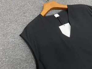 Detail of the V-neckline and fabric texture on a minimalist black sleeveless top