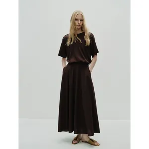 Minimalist dark brown two-piece set featuring short sleeve top and long pleated skirt