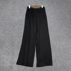 Détail d'un pantalon large noir avec taille élastique à cordon et tissu fluide léger